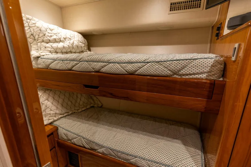 Miss Virginia Yacht Photos Pics Bunk beds in 2017 Viking 66 Convertible yacht cabin, featuring wooden frames and patterned bedding.