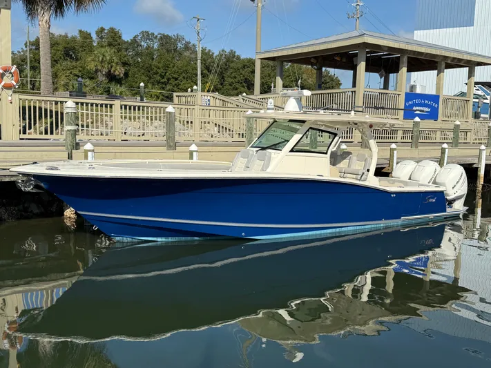 Giddy Up Yacht Photos Pics 2019 Scout 355 LXF CC boat docked, blue hull, calm water reflection.