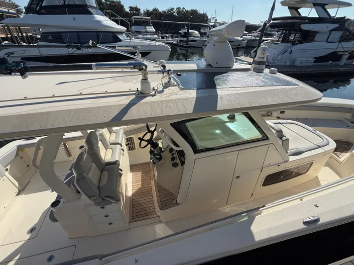 Giddy Up Yacht Photos Pics 2019 Scout 355 LXF CC boat interior with helm and seating, docked at marina.