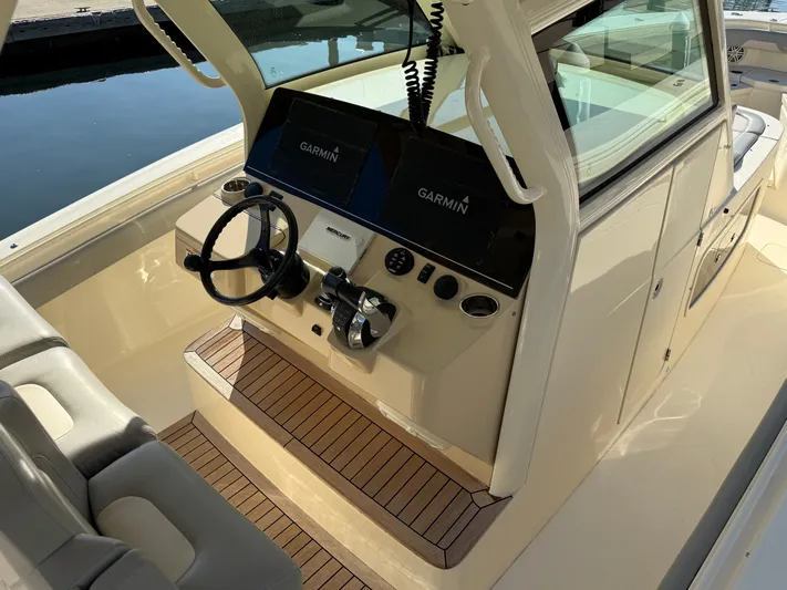 Giddy Up Yacht Photos Pics 2019 Scout 355 LXF CC boat helm with Garmin displays and wooden flooring.