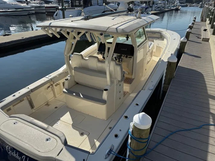 Giddy Up Yacht Photos Pics 2019 Scout 355 LXF CC boat docked at marina, showcasing spacious deck and seating.