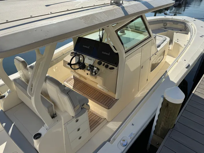 Giddy Up Yacht Photos Pics 2019 Scout 355 LXF CC boat with modern helm and seating, docked at marina.