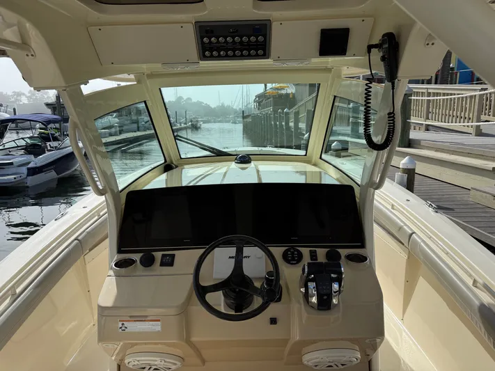 Giddy Up Yacht Photos Pics 2019 Scout 355 LXF CC boat helm with modern controls and waterfront view.