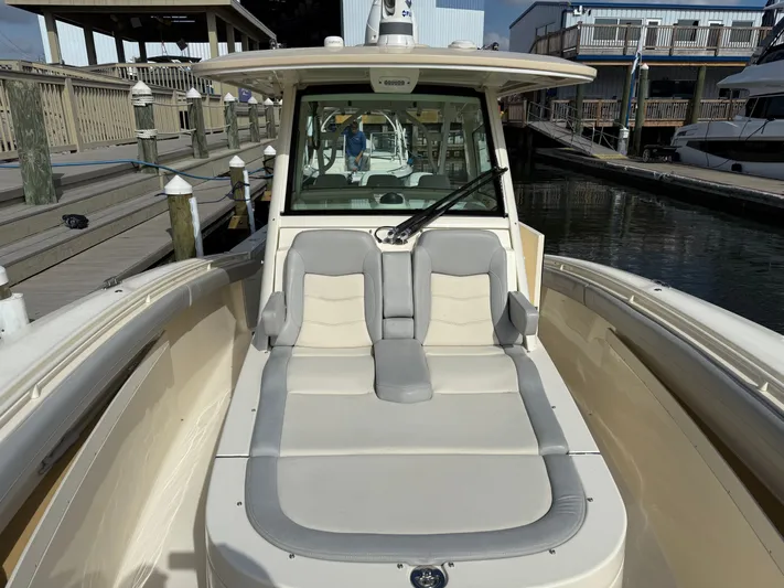 Giddy Up Yacht Photos Pics 2019 Scout 355 LXF CC boat with cushioned seating at a marina dock.