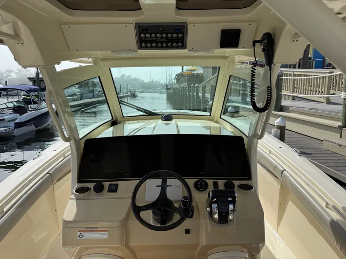 Giddy Up Yacht Photos Pics 2019 Scout 355 LXF CC boat helm with modern controls and waterfront view.