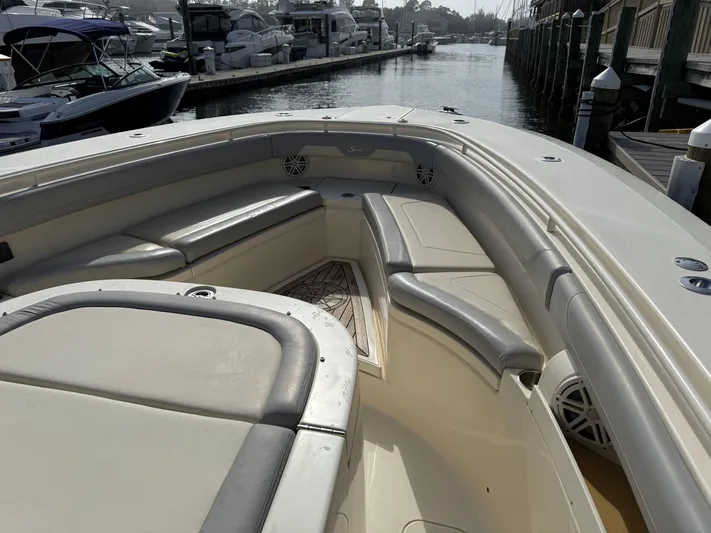 Giddy Up Yacht Photos Pics 2019 Scout 355 LXF CC boat interior with cushioned seating and docked boats in background.