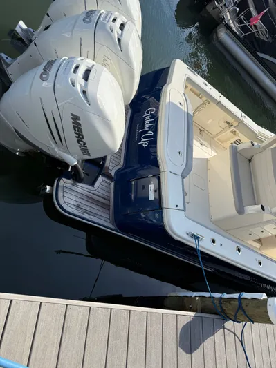 Giddy Up Yacht Photos Pics 2019 Scout 355 LXF CC boat with twin Mercury engines docked at a marina.