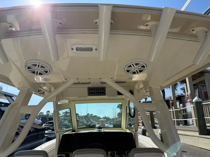 Giddy Up Yacht Photos Pics 2019 Scout 355 LXF CC boat interior with speakers and rod holders, docked under sunny skies.