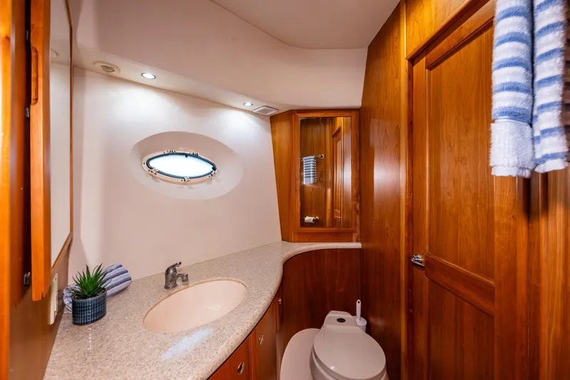 Infinite Yacht Photos Pics Luxurious bathroom in 2001 Silverton 410 Sport Bridge yacht with wood accents and porthole window.