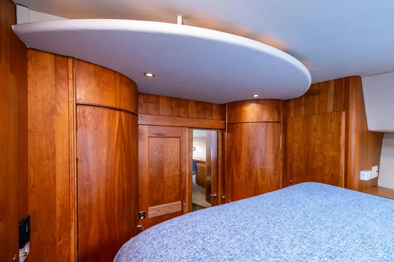 Infinite Yacht Photos Pics Interior of 2001 Silverton 410 Sport Bridge with wooden cabinetry and blue bedding.