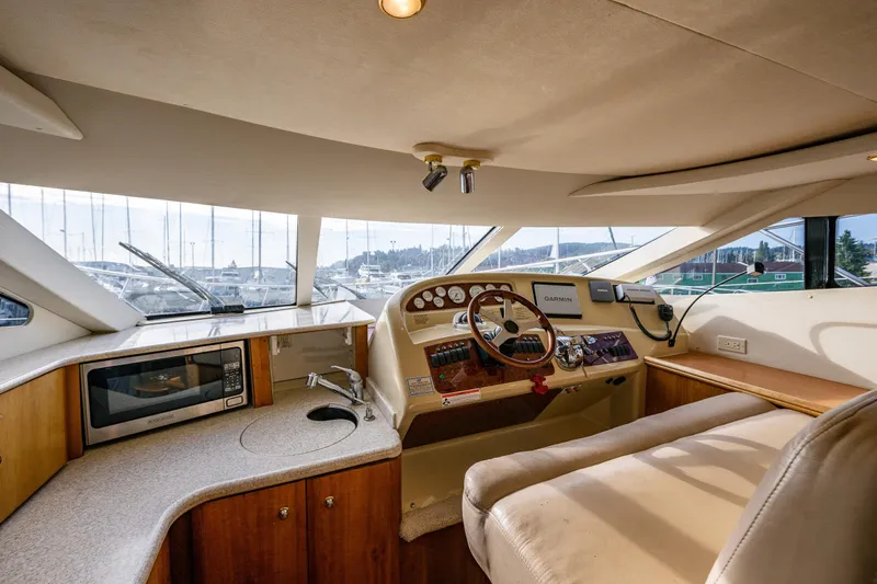 Infinite Yacht Photos Pics Interior of 2001 Silverton 410 Sport Bridge yacht with helm, microwave, and seating area.