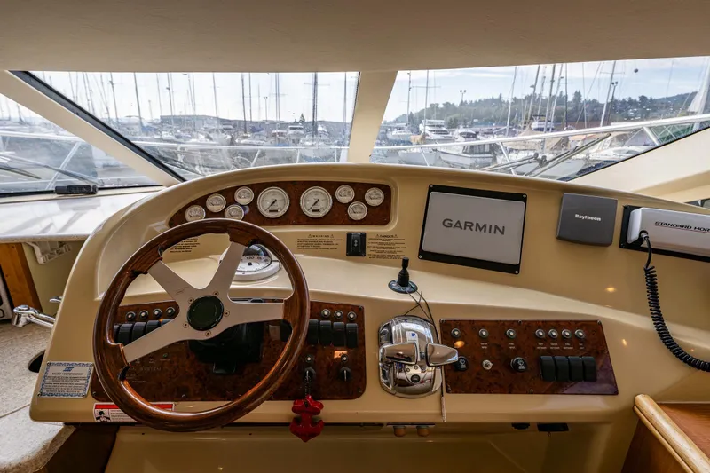 Infinite Yacht Photos Pics 2001 Silverton 410 Sport Bridge helm with Garmin navigation and wood-accented steering wheel.
