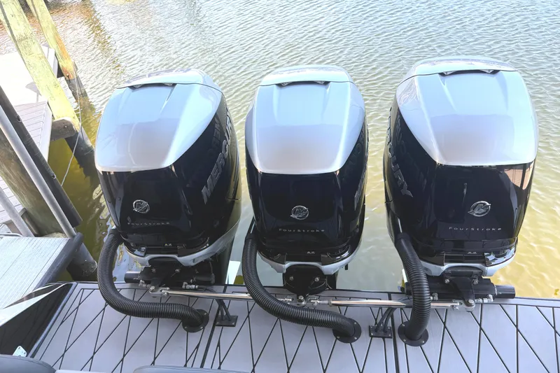  Yacht Photos Pics Three powerful outboard motors on a 2020 Statement 350 Open boat docked by the water.