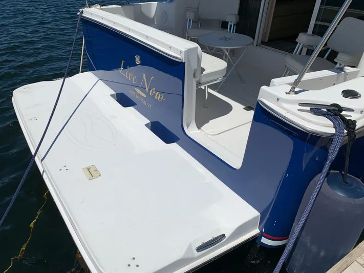 Live Now Yacht Photos Pics 2012 Silverton 33 Sport Coupe boat docked, featuring a spacious deck and seating area.