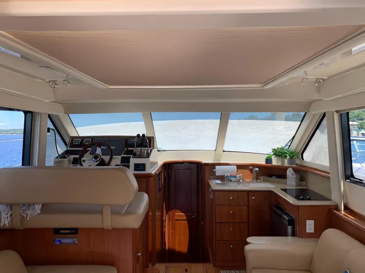 Live Now Yacht Photos Pics Interior of 2012 Silverton 33 Sport Coupe yacht with helm, kitchenette, and seating area.