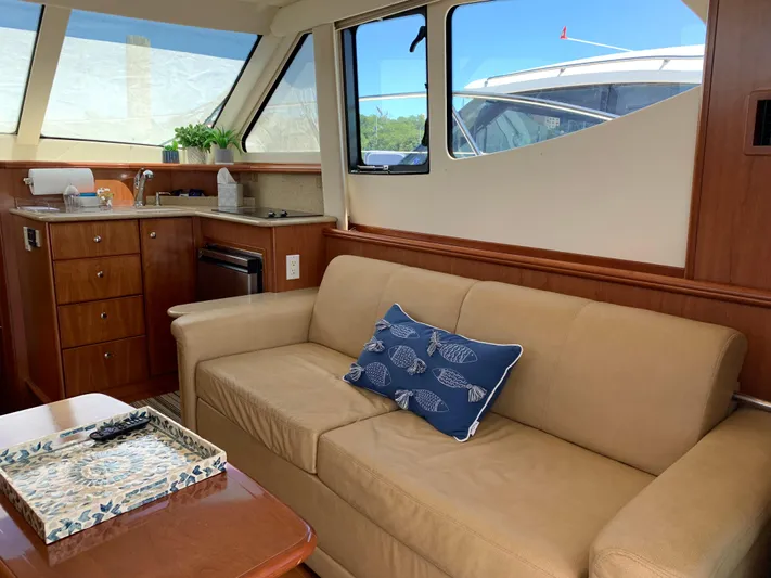 Live Now Yacht Photos Pics Interior of 2012 Silverton 33 Sport Coupe with beige sofa and kitchenette.