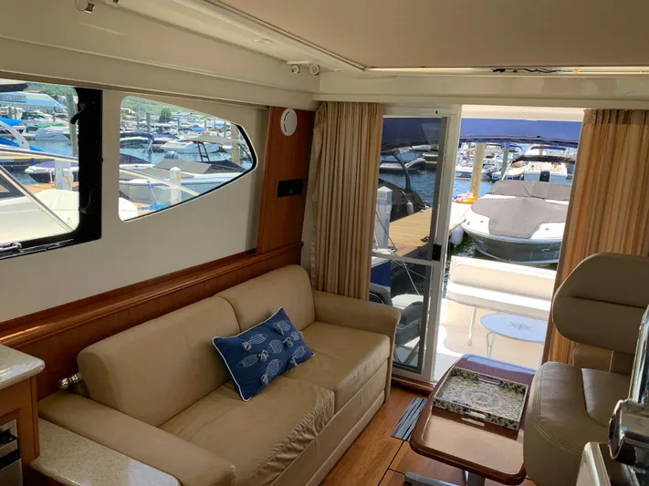 Live Now Yacht Photos Pics Interior of 2012 Silverton 33 Sport Coupe yacht with sofa and marina view.