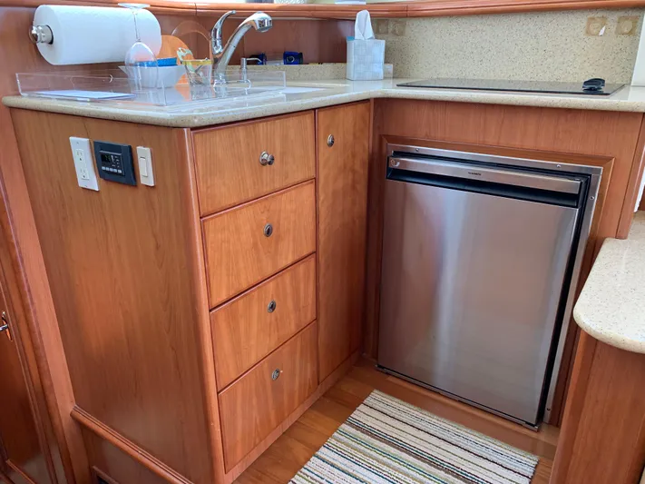 Live Now Yacht Photos Pics 2012 Silverton 33 Sport Coupe kitchen with wood cabinetry, stainless steel fridge, and countertop sink.