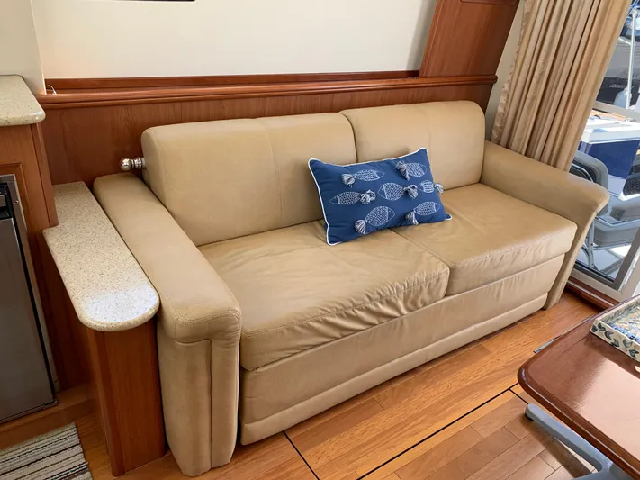 Live Now Yacht Photos Pics Beige sofa with blue fish-patterned pillow in 2012 Silverton 33 Sport Coupe interior.