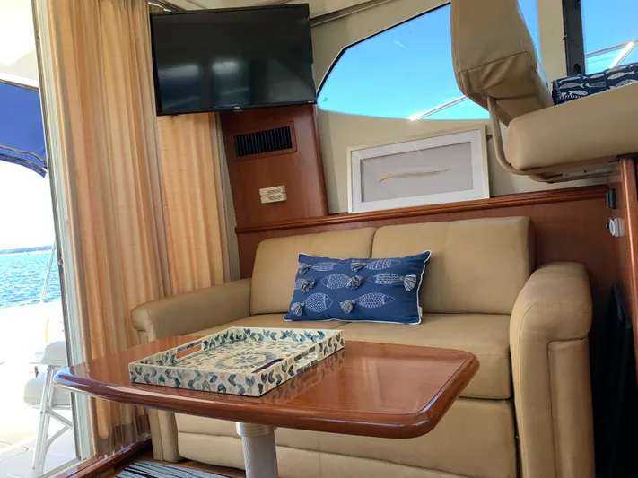 Live Now Yacht Photos Pics Interior of 2012 Silverton 33 Sport Coupe with beige sofa, TV, and nautical decor.