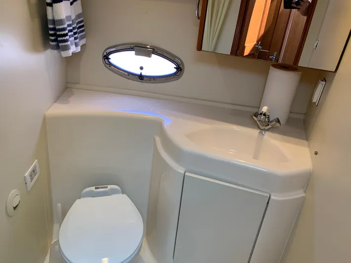Live Now Yacht Photos Pics Bathroom interior of 2012 Silverton 33 Sport Coupe with sink, toilet, and porthole window.