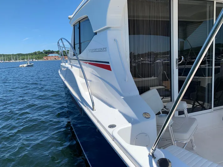 Live Now Yacht Photos Pics 2012 Silverton 33 Sport Coupe yacht docked on calm water.