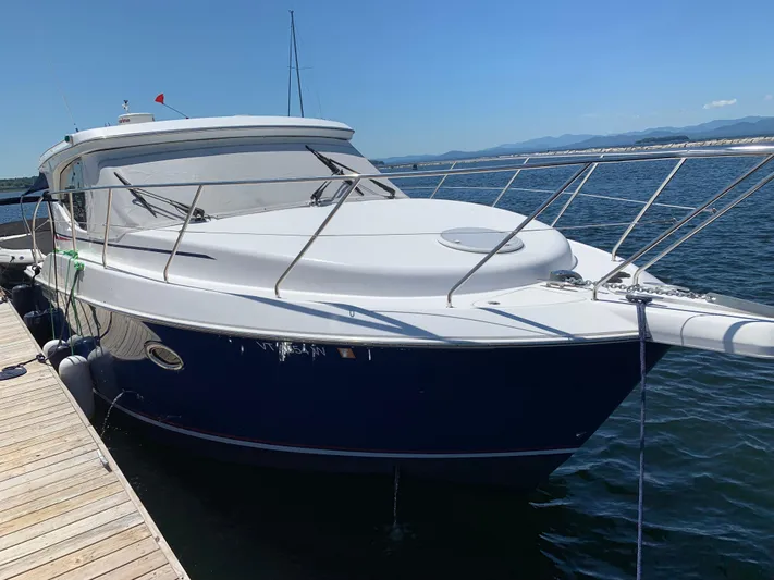 Live Now Yacht Photos Pics 2012 Silverton 33 Sport Coupe docked on a sunny day, with clear blue skies.
