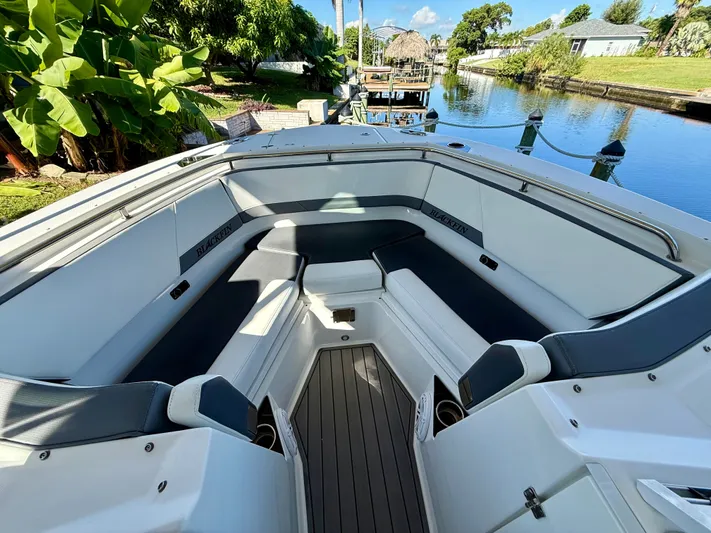  Yacht Photos Pics 2019 Blackfin 272 DC boat interior with sleek seating, docked by a scenic canal.