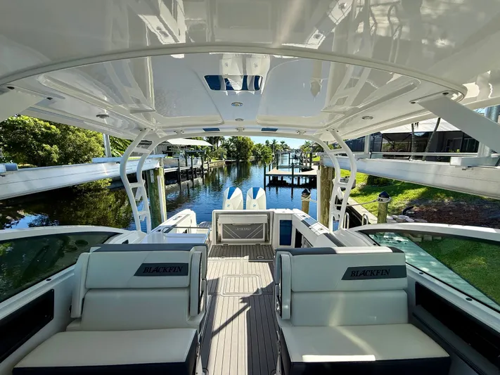  Yacht Photos Pics 2019 Blackfin 272 DC boat interior with seating, overlooking a serene waterfront dock.