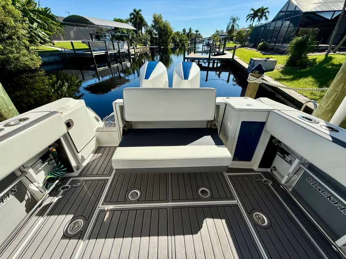  Yacht Photos Pics 2019 Blackfin 272 DC boat with spacious deck and seating, docked by a scenic canal.