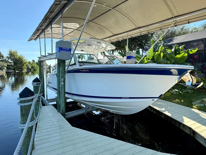  Yacht Photos Pics 2019 Blackfin 272 DC boat docked under canopy by a serene waterway.