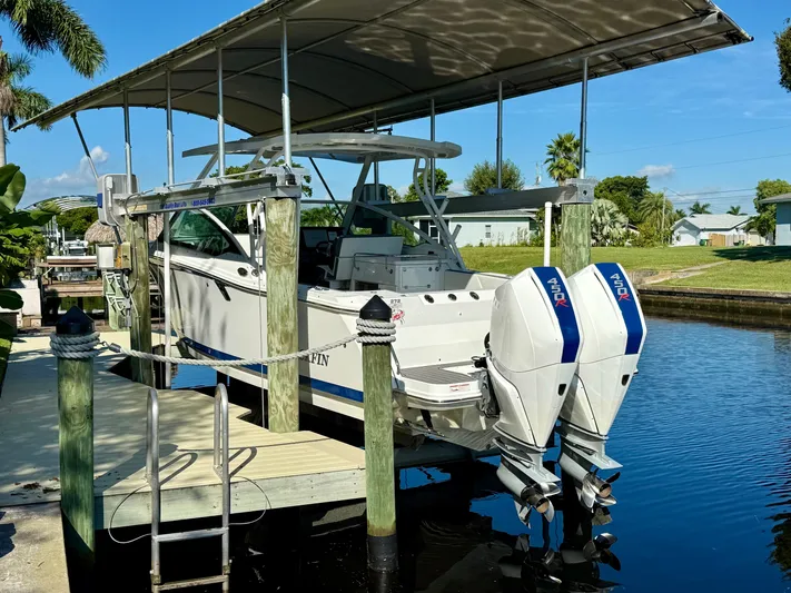  Yacht Photos Pics 2019 Blackfin 272 DC boat with twin engines docked under a canopy.