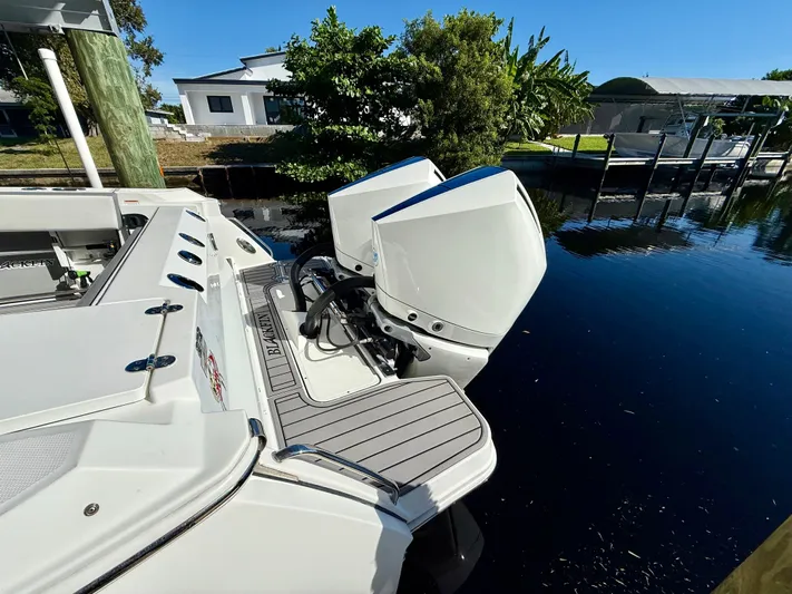  Yacht Photos Pics 2019 Blackfin 272 DC boat with dual outboard engines docked by the water.