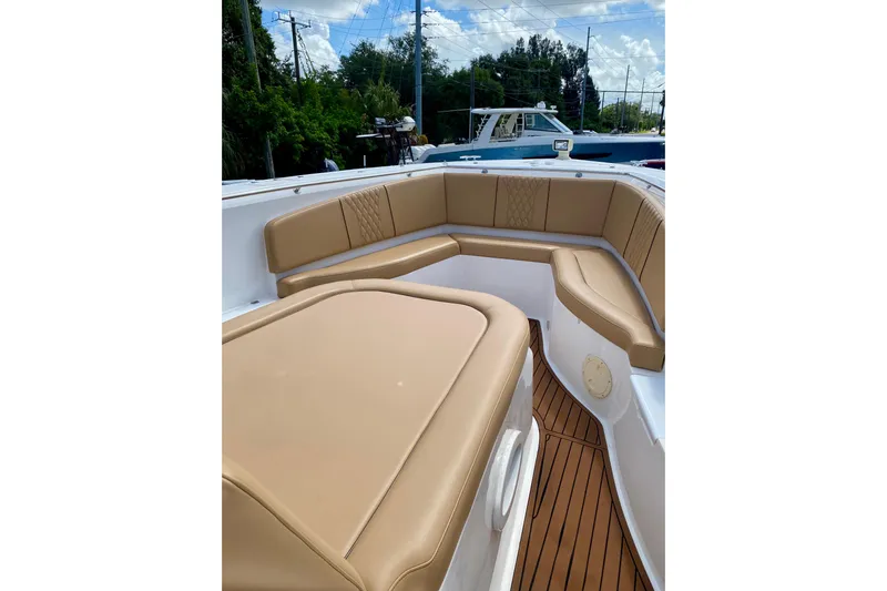  Yacht Photos Pics Luxurious seating on 2023 Fishing Raptor 390 Solarium boat, featuring tan upholstery and sleek design.