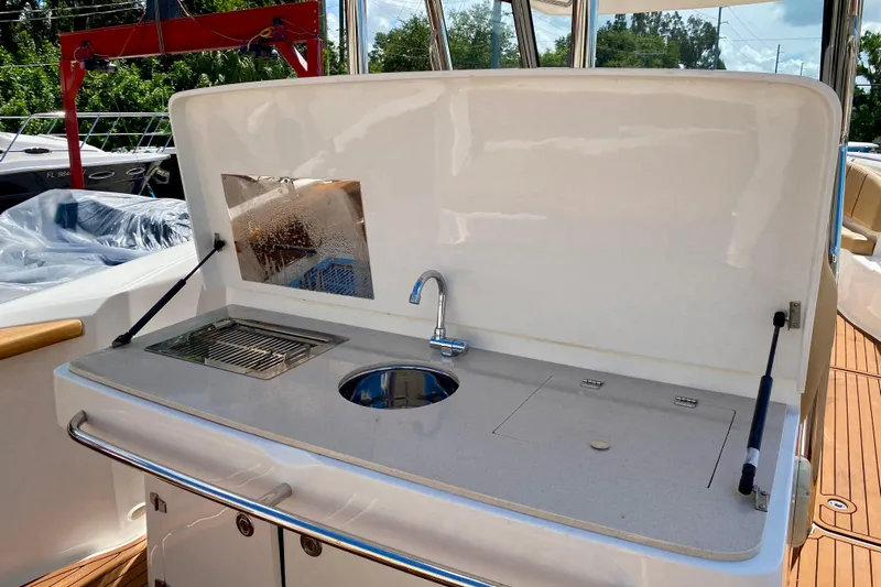  Yacht Photos Pics Outdoor kitchen on 2023 Fishing Raptor 390 Solarium boat with sink and grill.