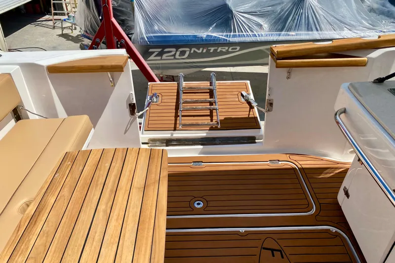  Yacht Photos Pics 2023 Fishing Raptor 390 Solarium boat interior with teak flooring and seating.