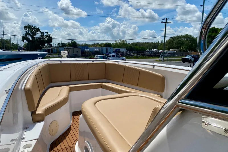  Yacht Photos Pics 2023 Fishing Raptor 390 Solarium boat with tan cushioned seating under a blue sky.