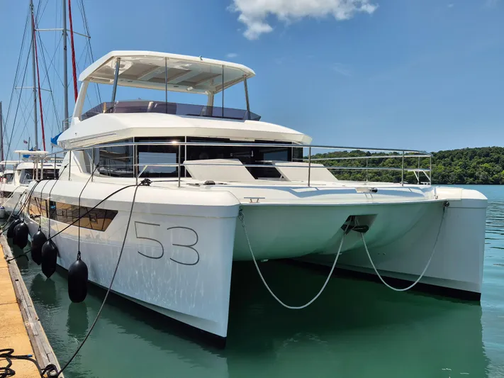  Yacht Photos Pics 2024 Leopard 53 Powercat yacht docked in serene marina setting.