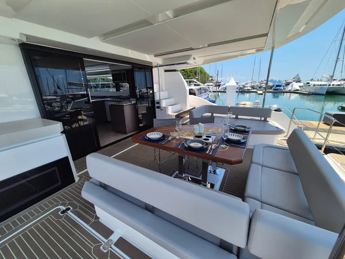  Yacht Photos Pics 2024 Leopard 53 Powercat yacht with elegant outdoor dining area and marina view.