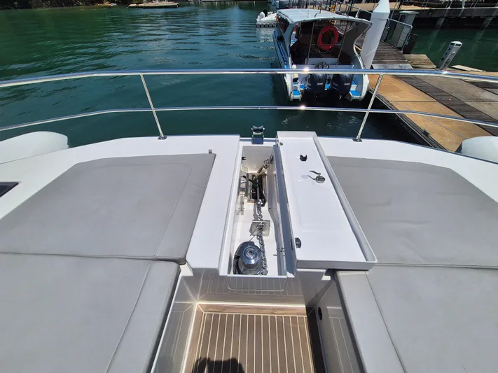  Yacht Photos Pics 2024 Leopard 53 Powercat deck with seating and storage, docked by the water.