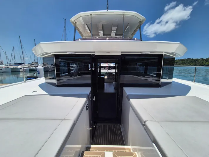  Yacht Photos Pics 2024 Leopard 53 Powercat yacht with sleek design, docked in a marina under clear blue skies.