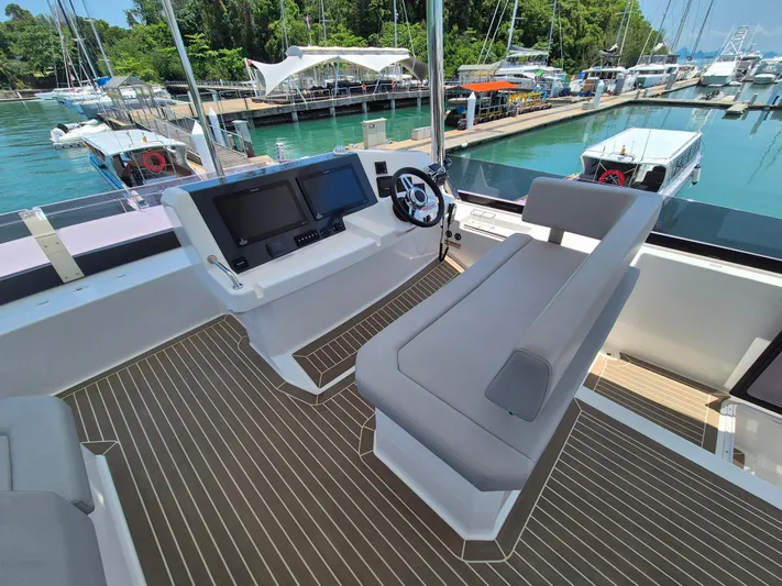  Yacht Photos Pics 2024 Leopard 53 Powercat helm station with modern controls, docked at a marina.