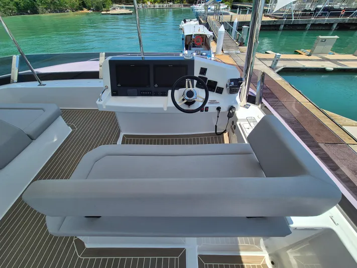  Yacht Photos Pics 2024 Leopard 53 Powercat helm station with modern controls and seating at a marina.