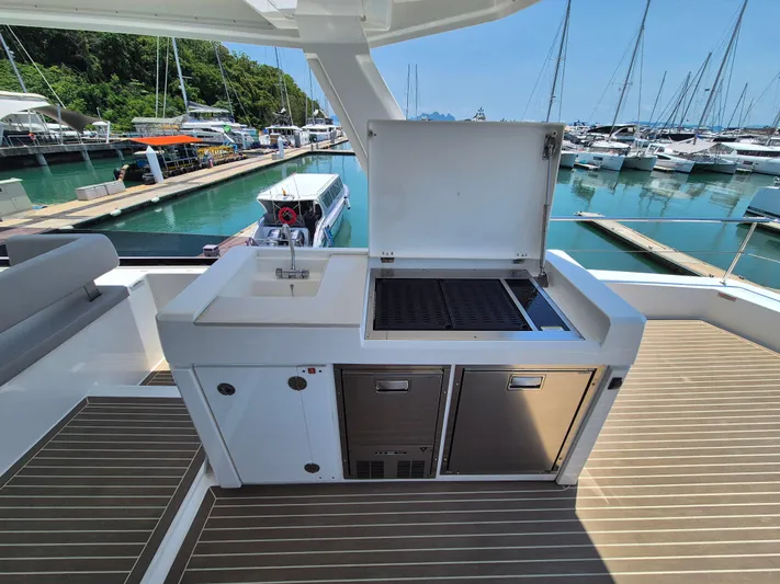  Yacht Photos Pics Outdoor kitchen on 2024 Leopard 53 Powercat yacht with grill and sink, docked at marina.