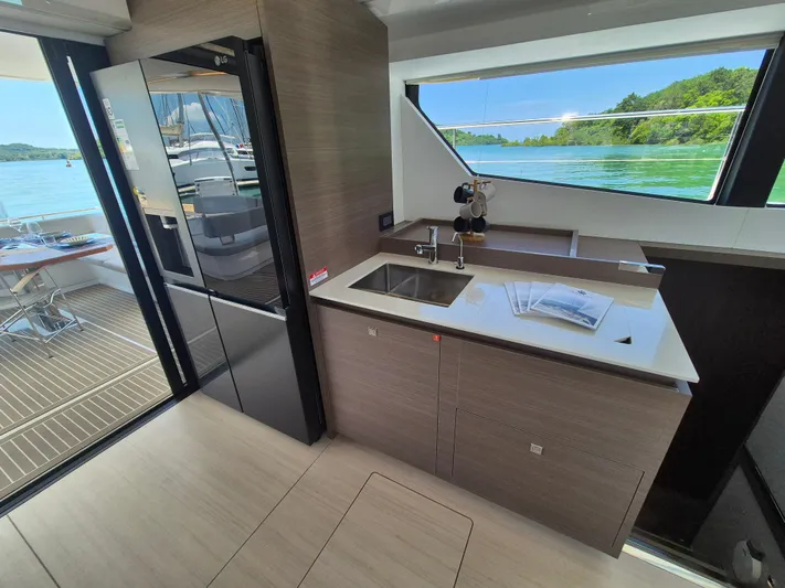  Yacht Photos Pics 2024 Leopard 53 Powercat kitchen with modern design, large windows, and outdoor view.