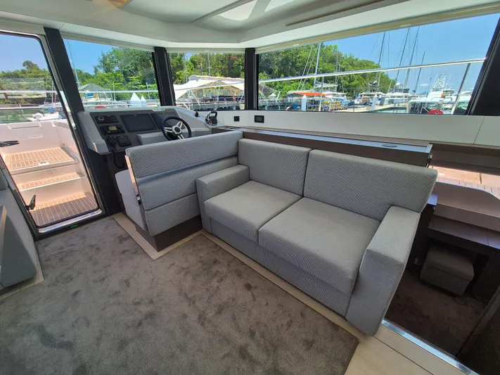  Yacht Photos Pics 2024 Leopard 53 Powercat interior with modern seating and helm, docked at marina.
