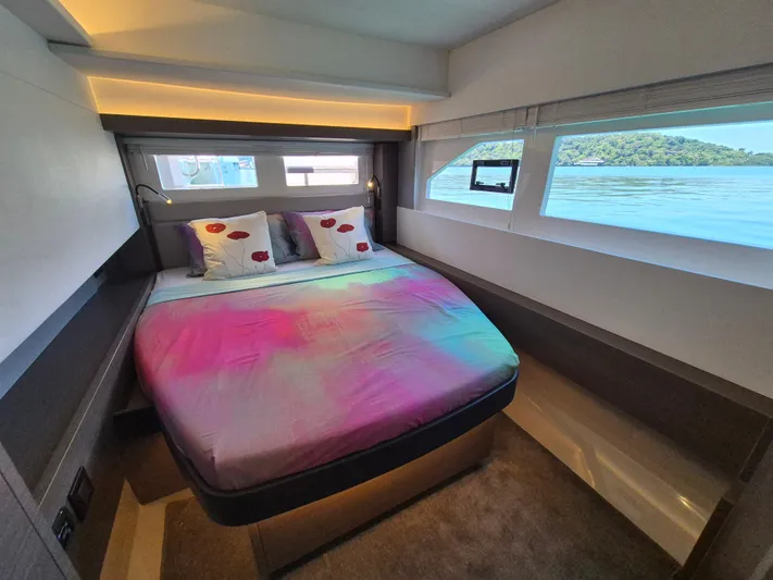  Yacht Photos Pics Luxurious bedroom interior of 2024 Leopard 53 Powercat with vibrant bedding and scenic window views.