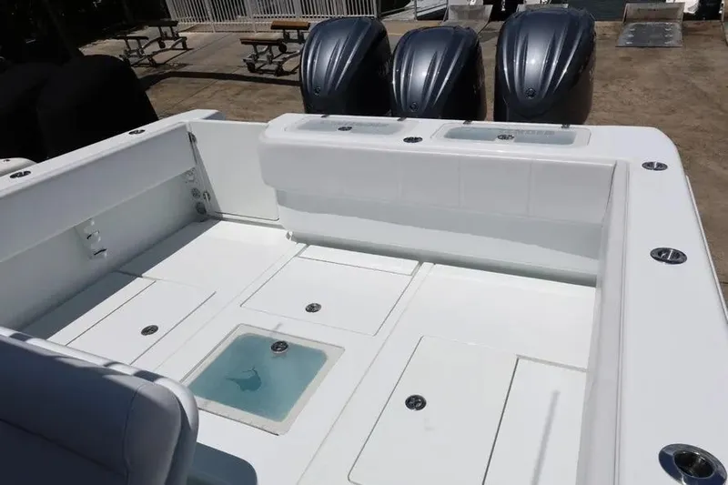  Yacht Photos Pics 2025 Contender 39 ST boat deck with triple outboard engines, featuring storage compartments.