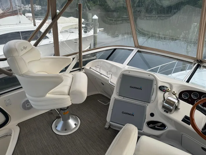 Messing About Yacht Photos Pics 2003 Sea Ray 400 Sedan Bridge helm with Garmin navigation, luxurious seating, and waterfront view.