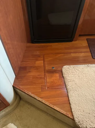 Messing About Yacht Photos Pics Interior of 2003 Sea Ray 400 Sedan Bridge with wooden flooring and beige carpet.